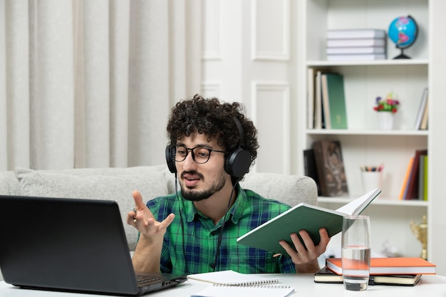 수업을 설명하는 녹색 셔츠에 안경에 컴퓨터에서 공부하는 학생 온라인 귀여운 젊은 남자