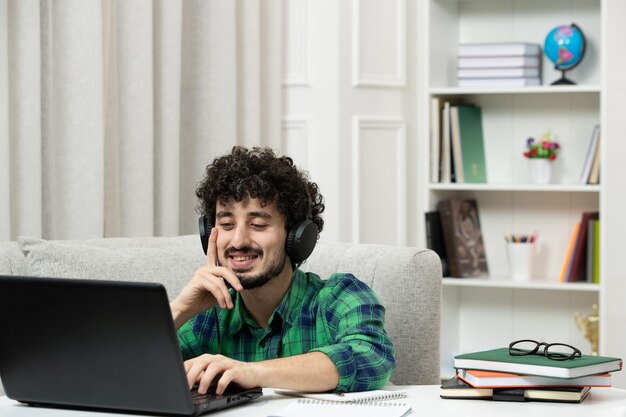 노트북에 입력하는 녹색 셔츠에 안경에 컴퓨터에서 공부하는 학생 온라인 귀여운 젊은 남자