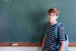 Free photo student posing with backpack and blackboard