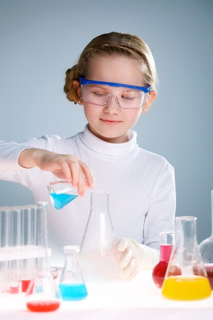 Student pouring liquid into a bigger flask