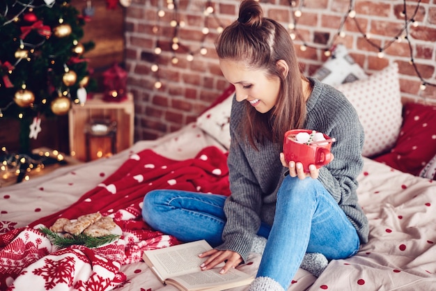 Student reading a book on bed