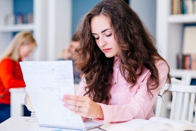 Student reading notes in library