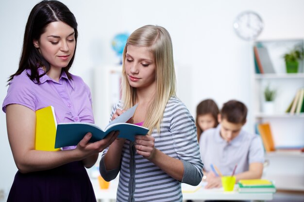 Student showing her homework to the teacher