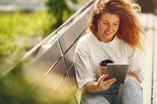 Student sitting in a city with a tablet