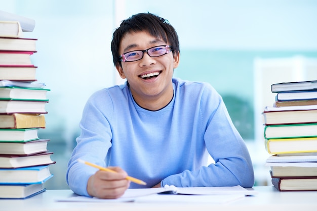 Free photo student sitting at desk with books on table