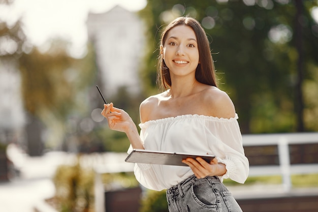 Student standing in a city with a tablet