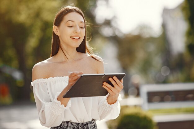 タブレットで街に立つ学生