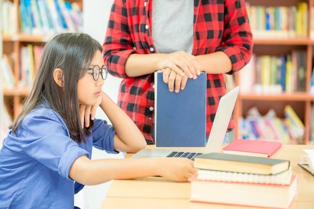 学校の図書館で勉強している学生