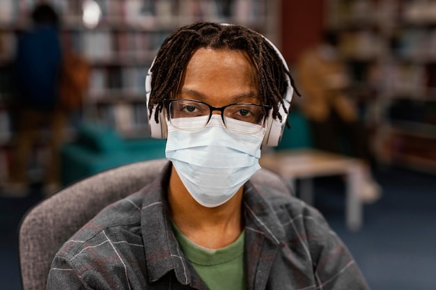 도서관에서 얼굴 마스크를 착용하는 학생