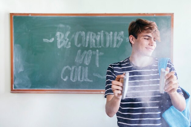 Student with blackboard and chalk dust