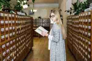 Foto gratuita studente con il libro che guarda l'obbiettivo