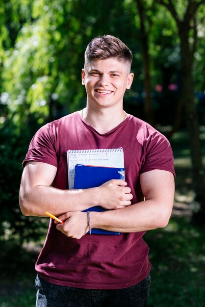 Student with notebook and book in garden