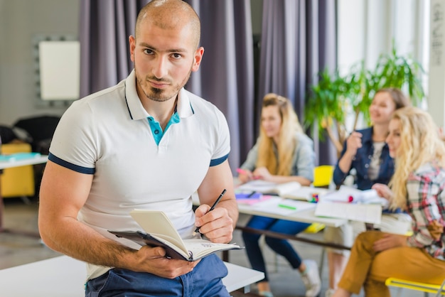 Student with notebook posing in classroom