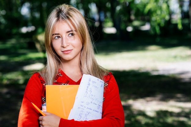 Student with notepad in park