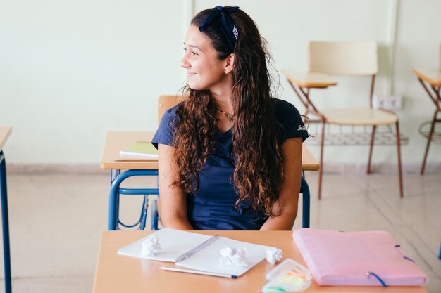 彼女の机の上に学校の資料を持っている学生