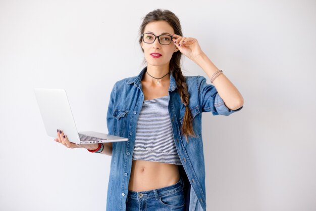 Student woman standing with a laptop in her hands