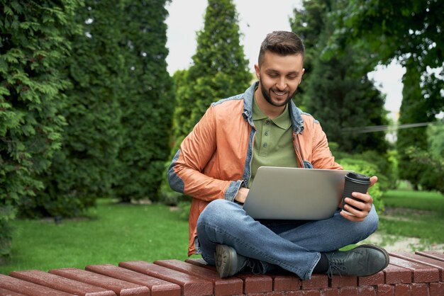 Student working with laptop in garden