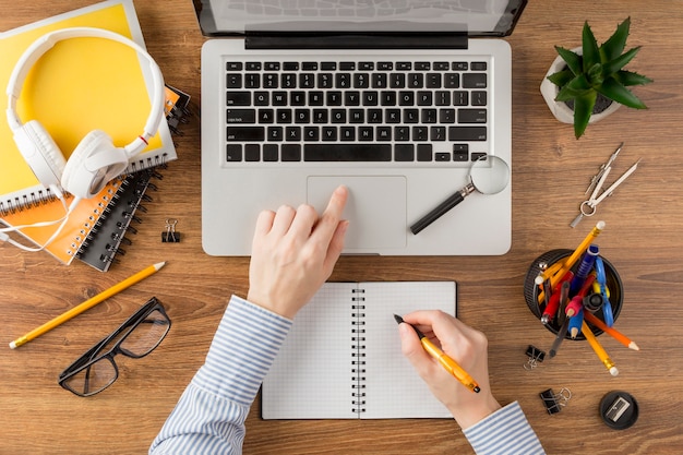 Student writing on a notebook on desk