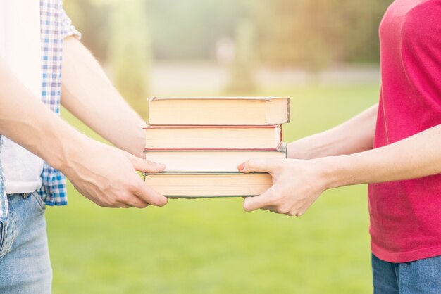 Students holding books in park