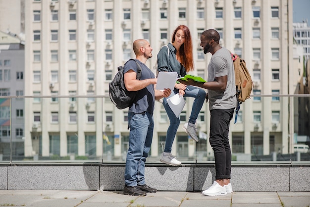 Free photo students holding notebooks talking