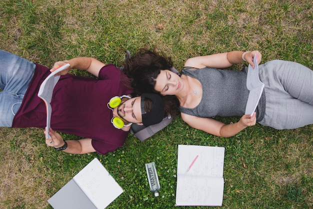 Students lying on grass reading