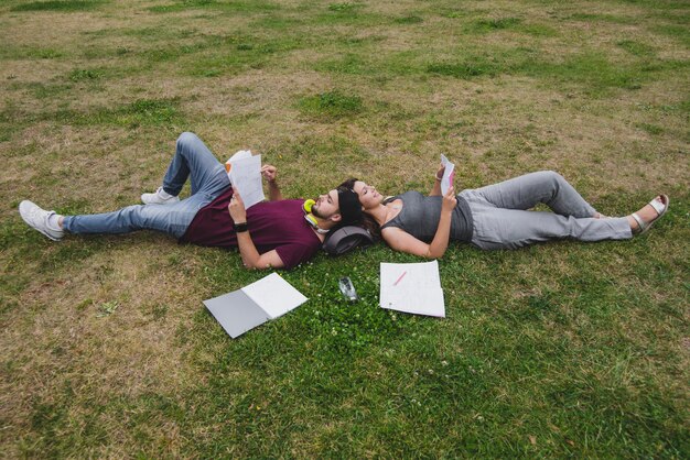 Students lying on grass reading