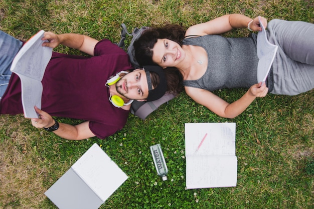 Foto gratuita studenti che si trovano sulla lettura dell'erba