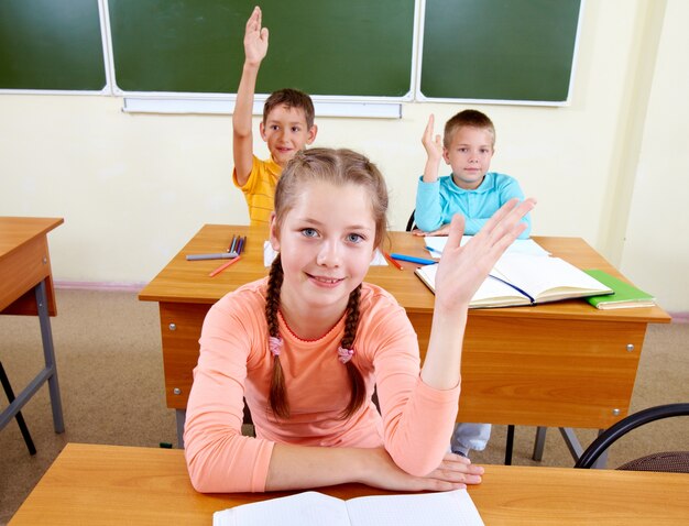 Students raising their hands in the classroom