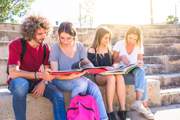 ステップ上に座って勉強している学生