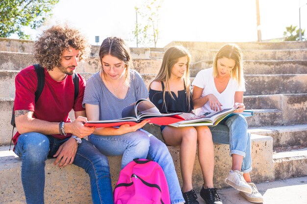 ステップ上に座って勉強している学生