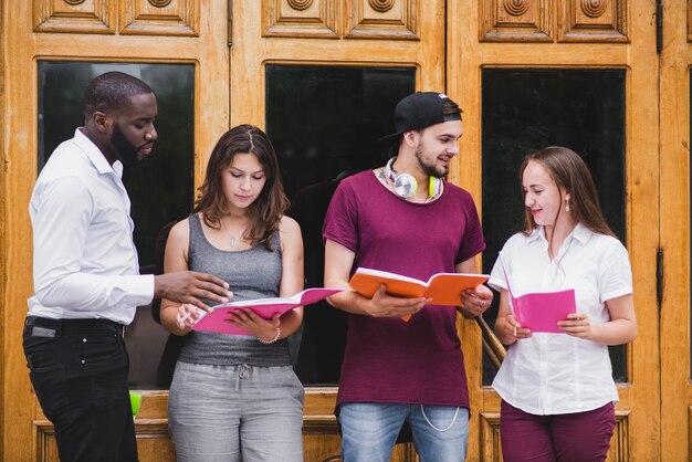 Students standing against doors reading