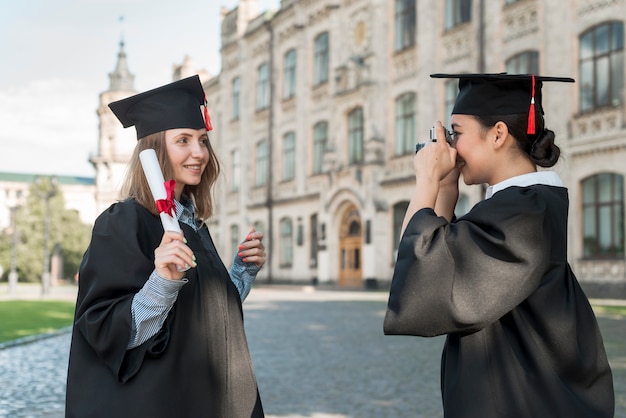 Студенты фотографируют друг друга на выпускном