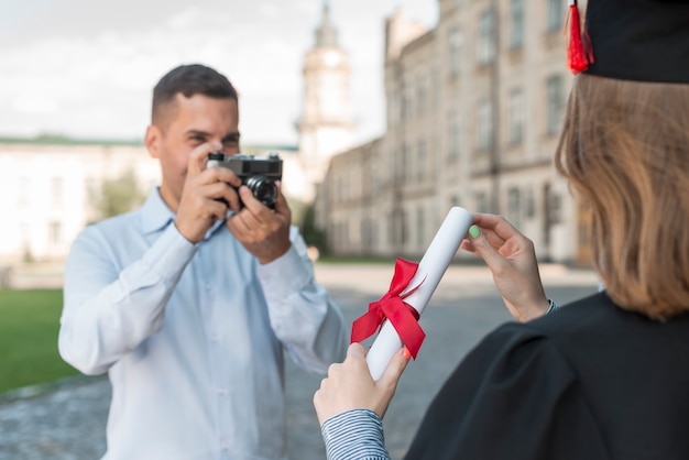 Студенты фотографируют друг друга на выпускном