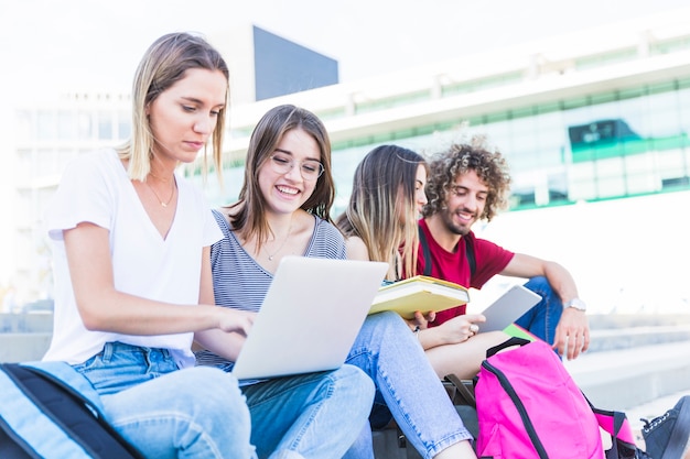 Students with digital devices on street