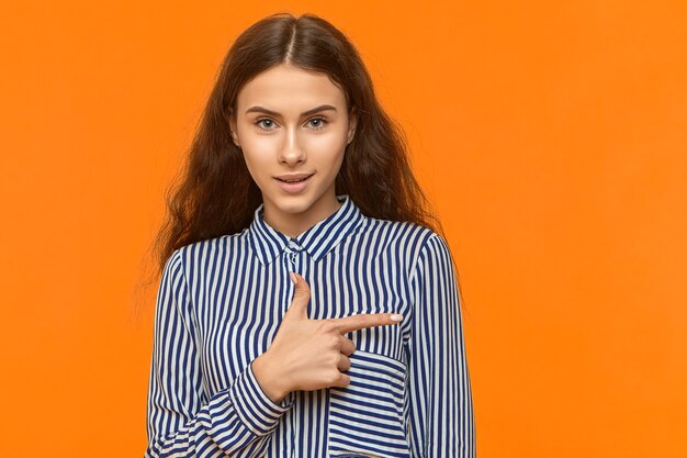 Studio image of cheerful joyful young Caucasian brunette female having excited look