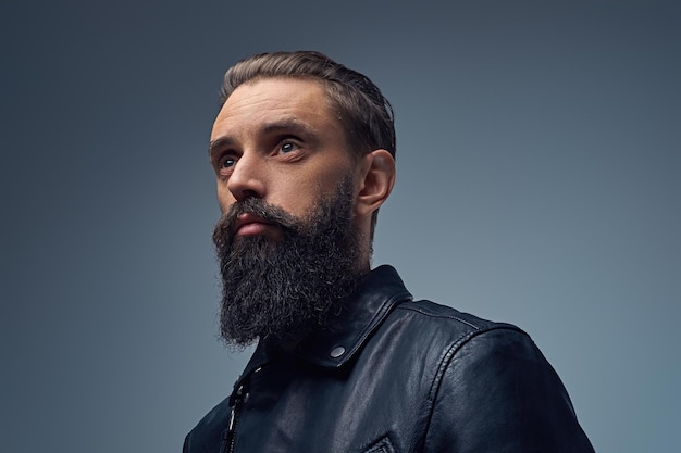 Studio portrait of bearded male dressed in black leather jacket.