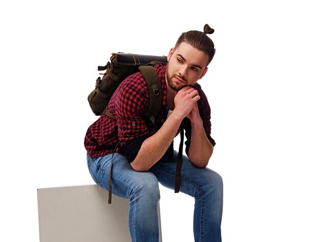 Studio portrait of bearded male dressed in a jeans and fleece shirt with a backpack. Isolated on white background.