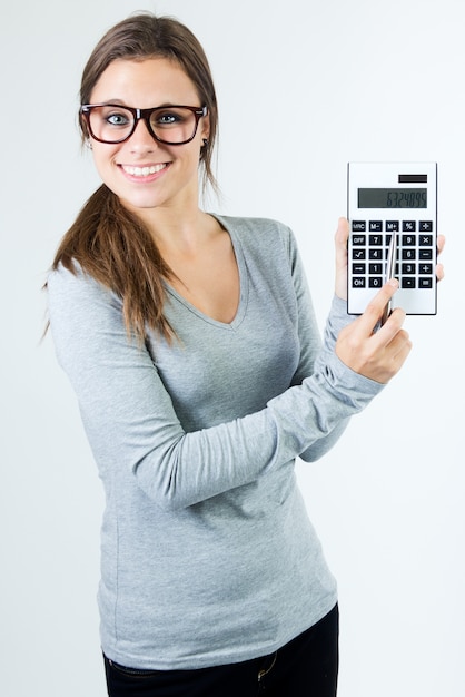 Studio portrait of beautiful young woman posing with calculator