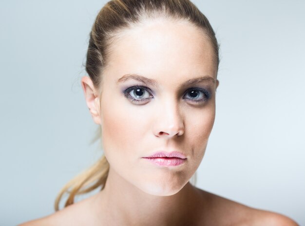 Studio Portrait of beautiful young woman posing with white screen