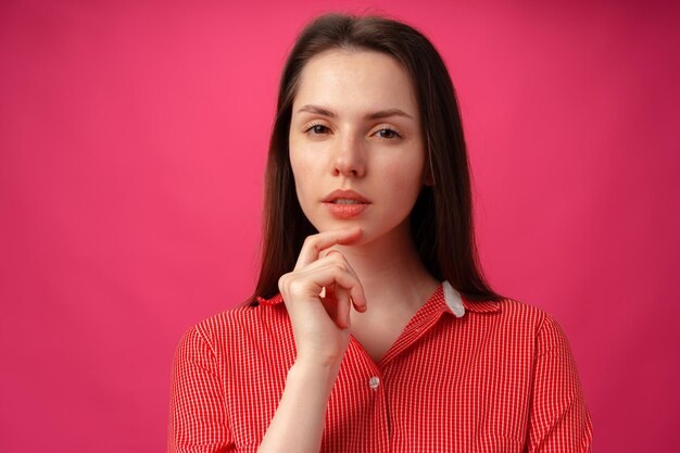 Studio portrait of beautiful young woman thinking against pink background