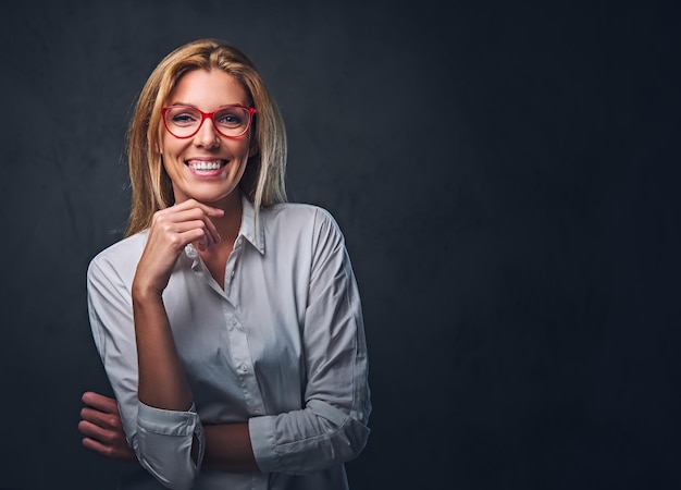 Free photo studio portrait of blond female dressed in a white shirt and red eyeglasses.