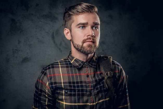 Foto gratuita ritratto in studio di un maschio hipster con la barba e gli occhi azzurri su sfondo grigio.