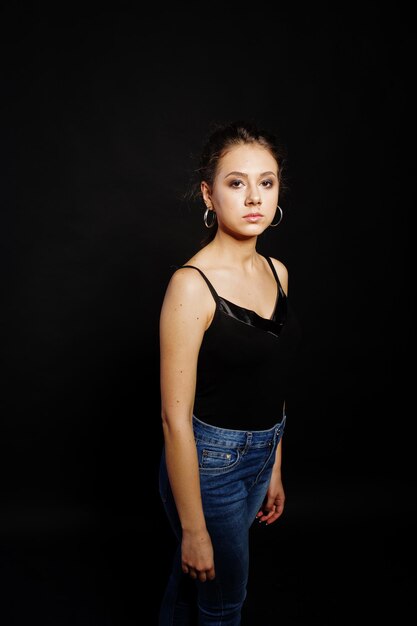 Studio portrait of brunette girl with make up on black background