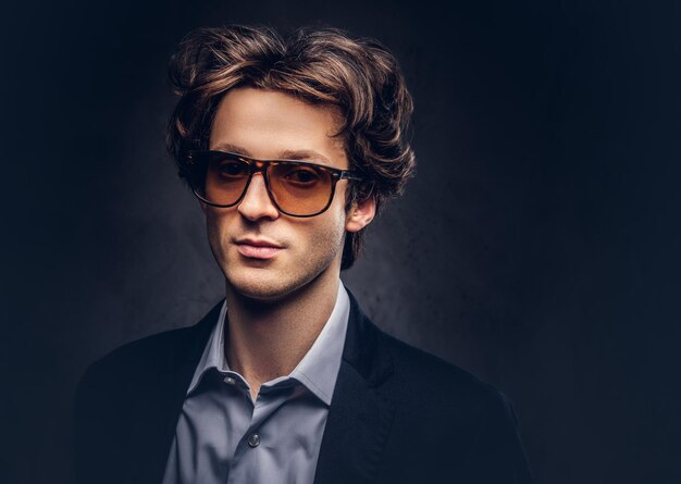 Studio portrait of a charismatic sensual macho with stylish hair and sunglasses