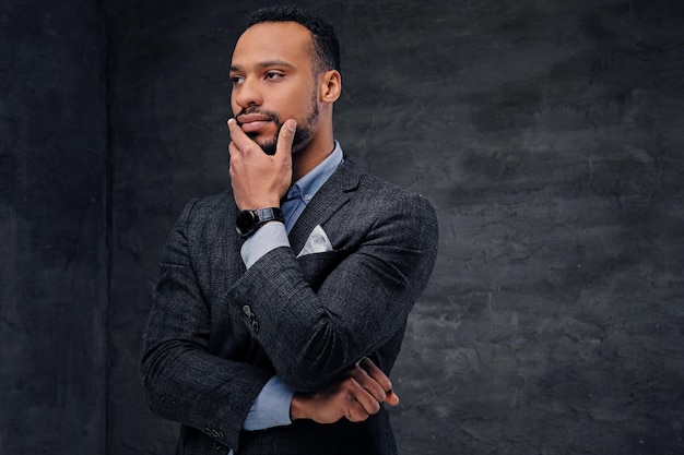 Studio portrait of elegant black American male dressed in a suit over grey vignette background.