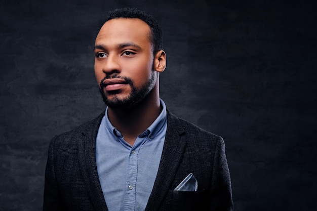 Studio portrait of elegant black American male dressed in a suit over grey vignette background.