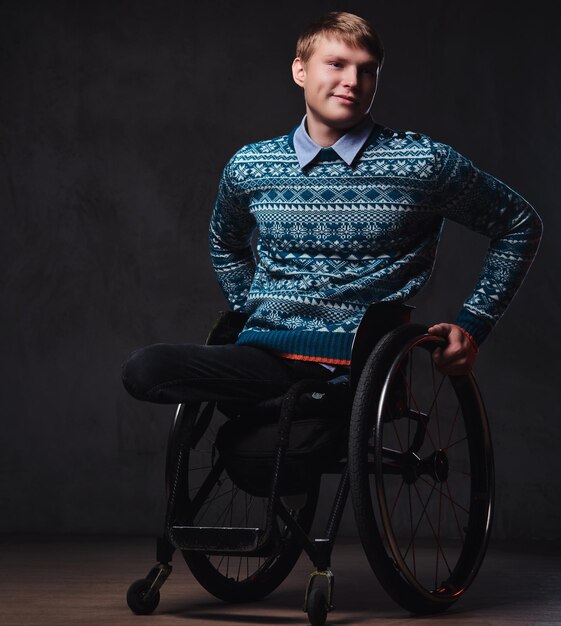 Studio portrait of a man in wheelchair over grey background.