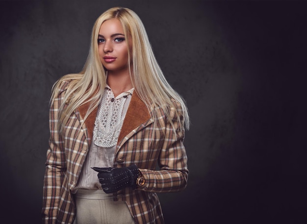 Studio portrait of old fashioned blonde female on grey background.