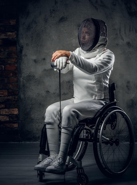 Studio portrait of paralympic female fencer in wheelchair.