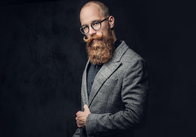 自由摄影工作室肖像的红头发胡须的男性在复古眼镜穿着羊毛夹克。